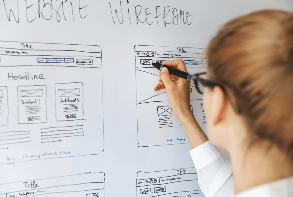 Wireframe de baixa fidelidade de Website Mulher desenhando wireframe de site de baixa fidelidade no quadro branco