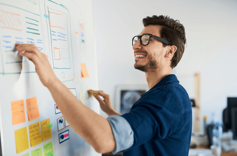 teste de usabilidade apresentação Um homem apresentando o teste de usabilidade em um quadro branco.
