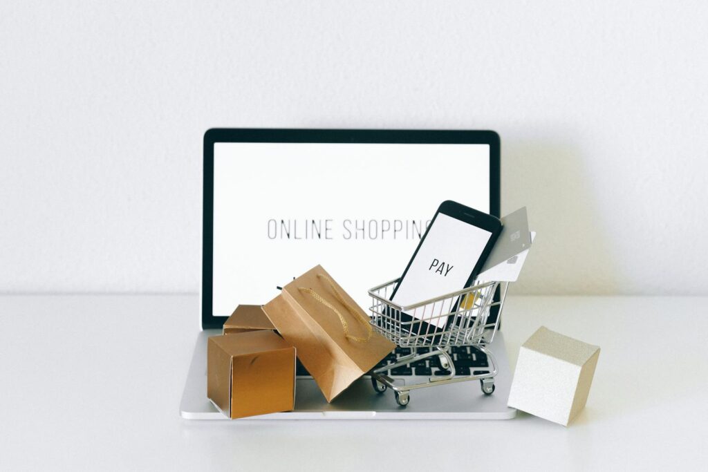 computador com miniaturas de carrinho de compras para software para e-commerce